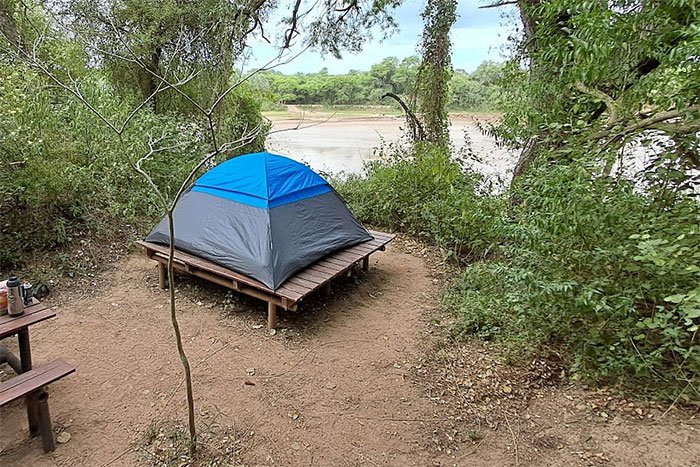 Carpa sobre plataforma de acampe junto al río, Camping La Fidelidad, El Impenetrable