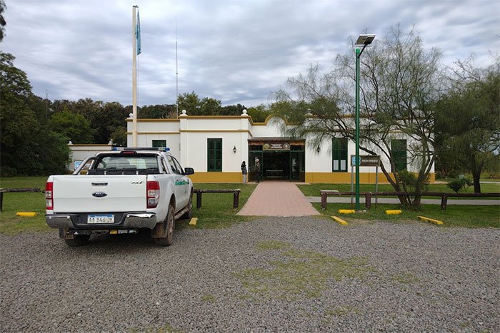 Edificio blanco del centro de visitantes con camino de acceso y camioneta de guardaparques, Parque Nacional Ciervo de los Pantanos