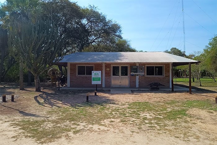 Edificio del centro de visitantes entre árboles y palmeras, Parque Nacional Río Pilcomayo