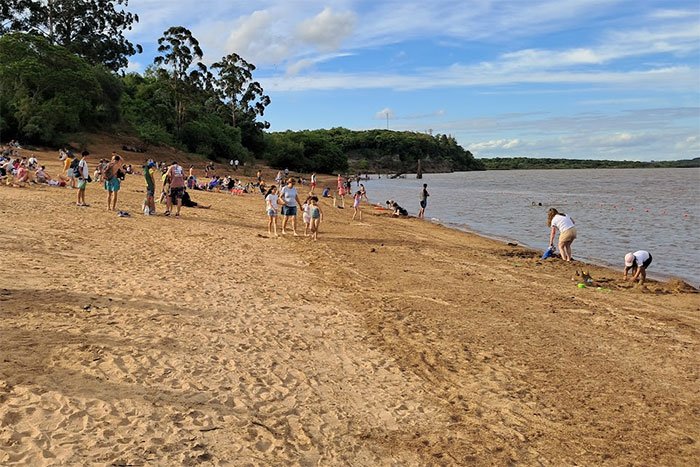 Playa de arena con bañistas sobre el río Uruguay, Parque Nacional El Palmar