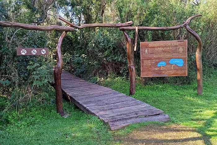 Portal de troncos y pasarela de madera al inicio del Sendero de las Lagunas, Parque Nacional Pre-Delta